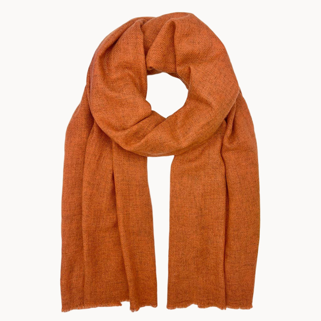 Terracotta-colored cashmere scarf on a white background