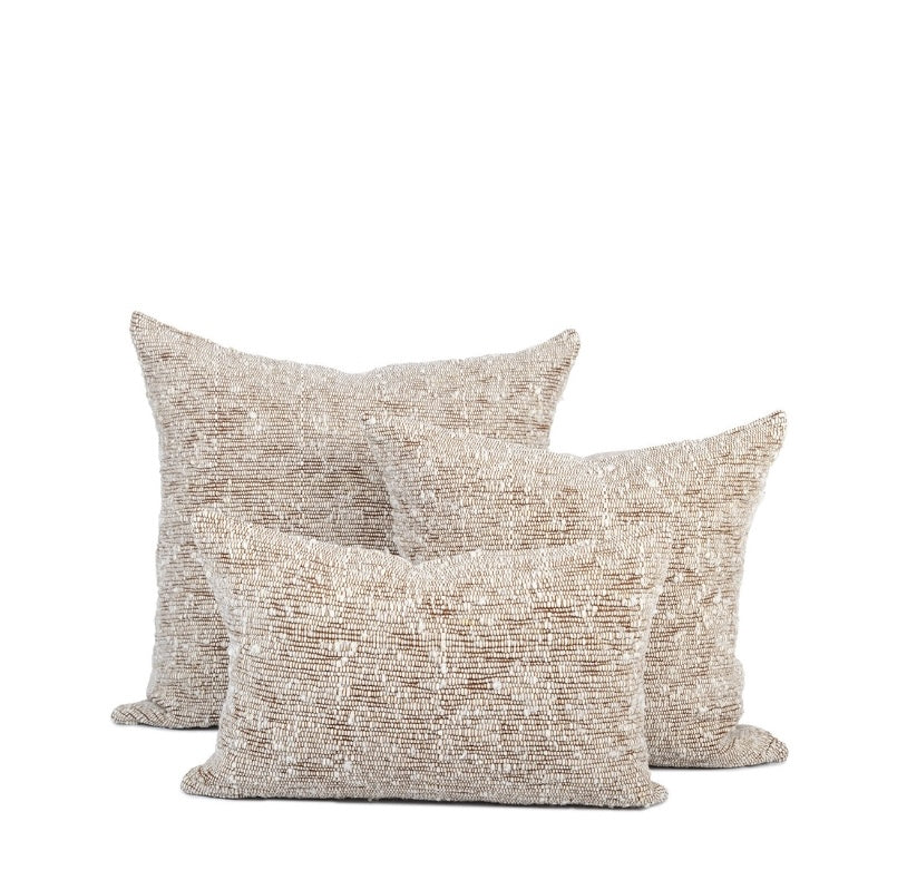 Trio of ivory and chestnut chunky wool woven pillows in three different sizes sits against white background
