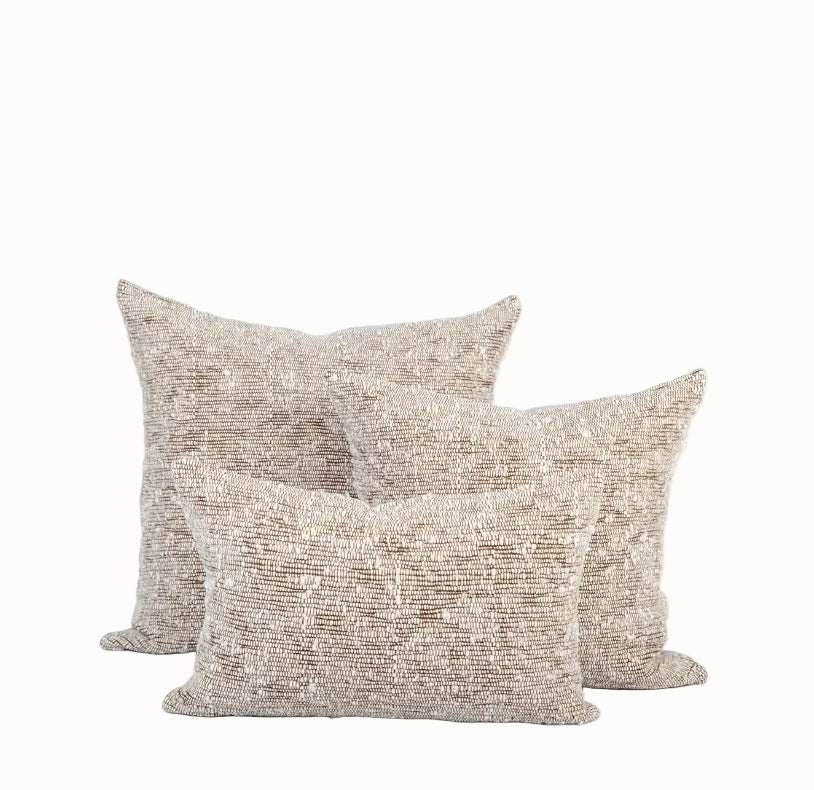 Trio of ivory and chestnut chunky wool woven pillows in three different sizes sits against white background