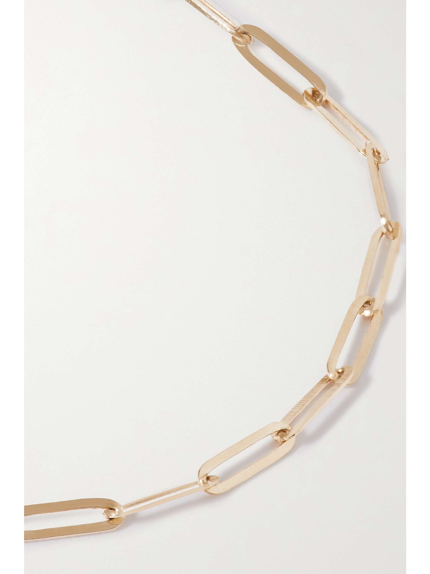 A closeup of a gold chainlink-style bracelet laying flat on a white background