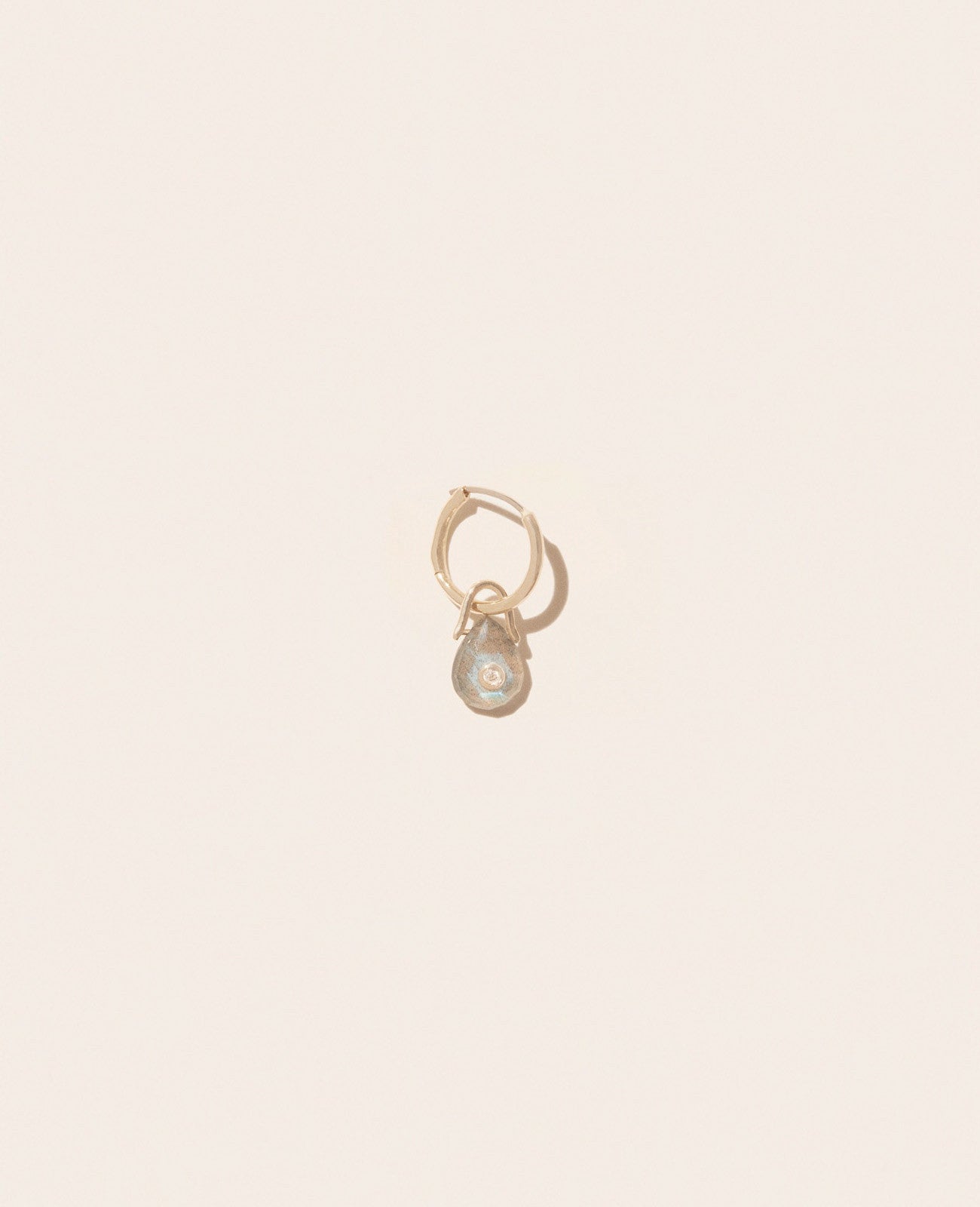 A single gold hoop earring with a smoky Labradorite gemstone and a small diamond
