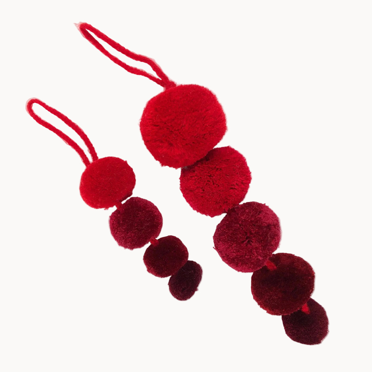Red and burgundy pom-pom ornament on a white background