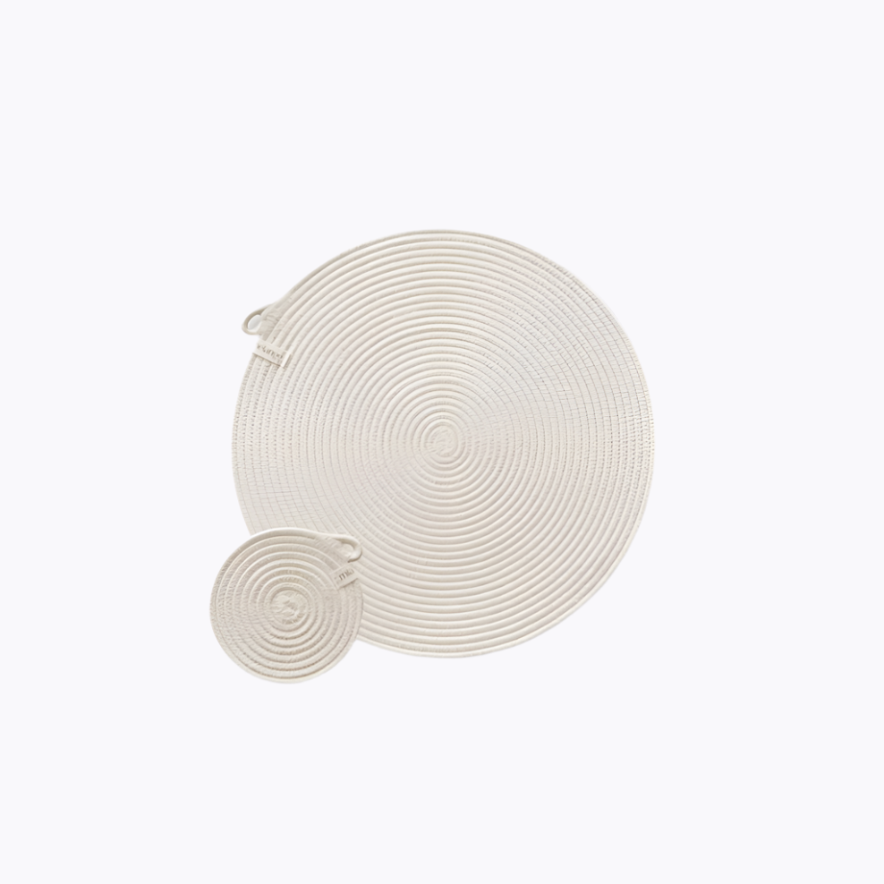 A set of white placemats and coasters with a woven texture, displayed on a white background.