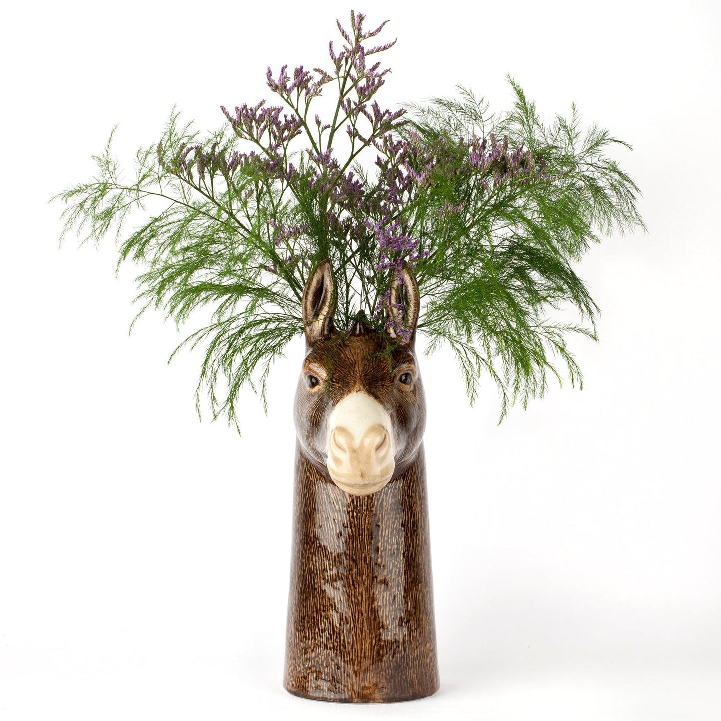 Donkey-shaped vase with floral arrangement on a white background