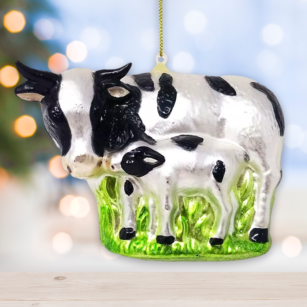 Cow and calf ornament on a grassy patch with blurred lights in the background