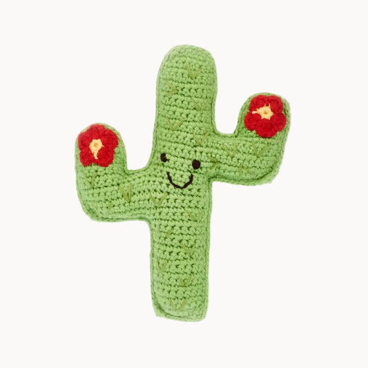 Crocheted cactus toy with a smiley face on a white background