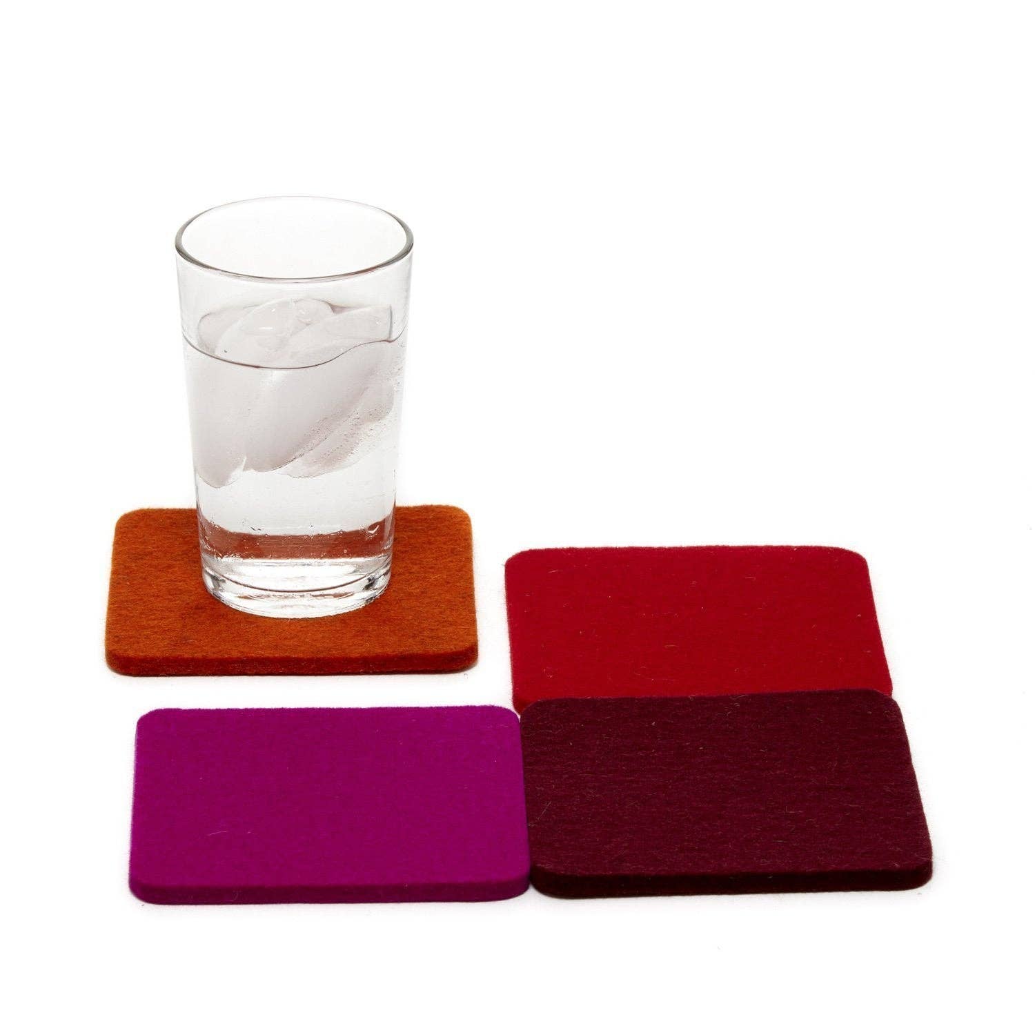 Set of colorful wool coasters with a glass of water on a white background