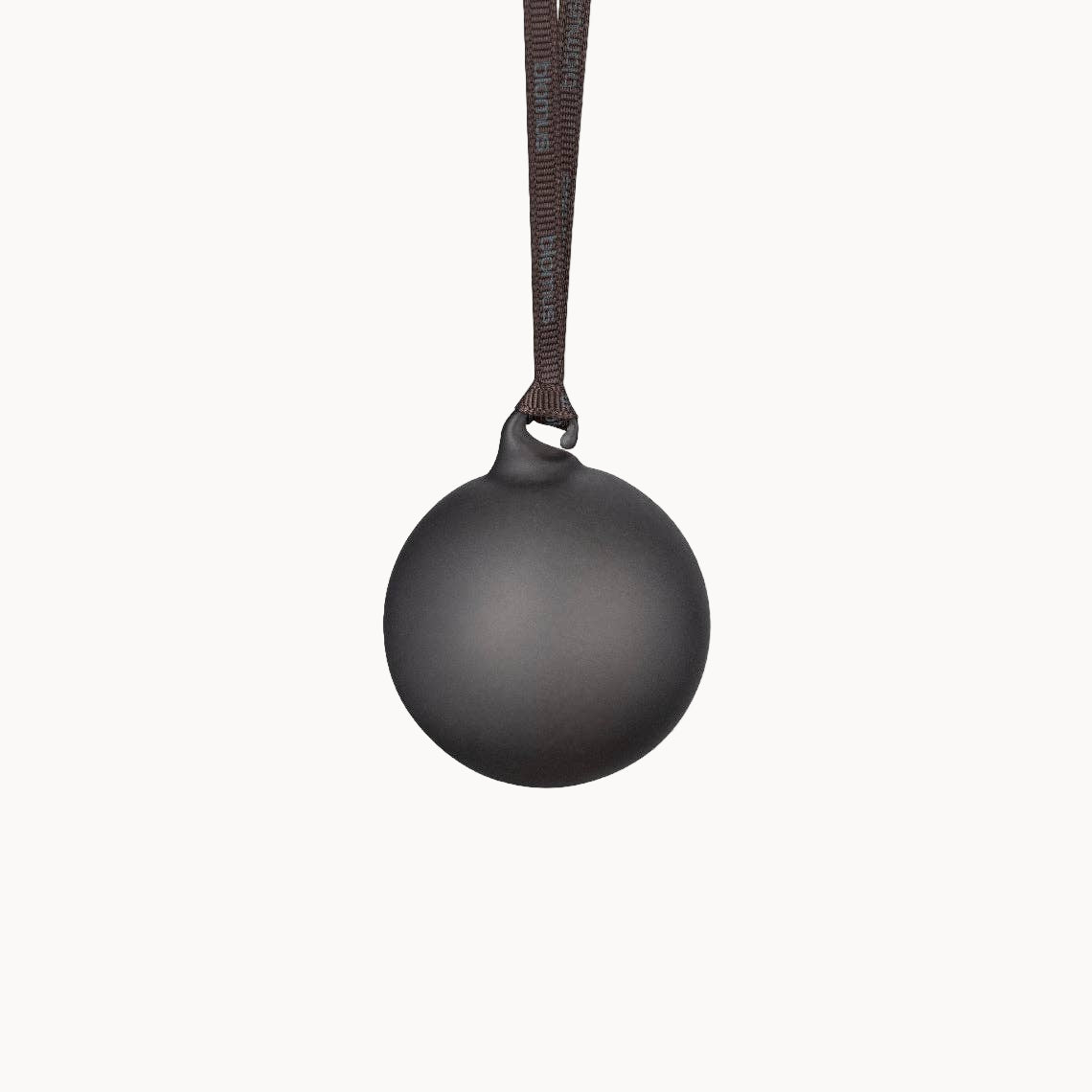 Black spherical pendant on a brown cord against a white background