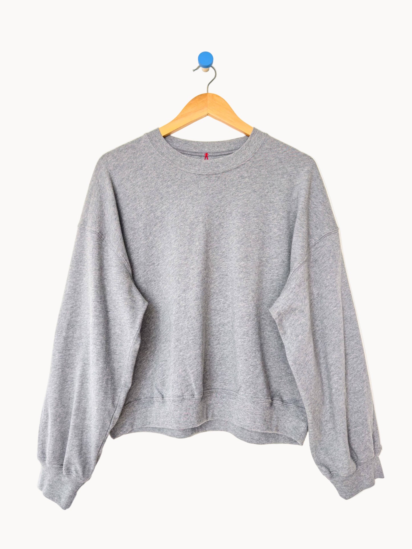 Gray sweatshirt on a hanger against a white background