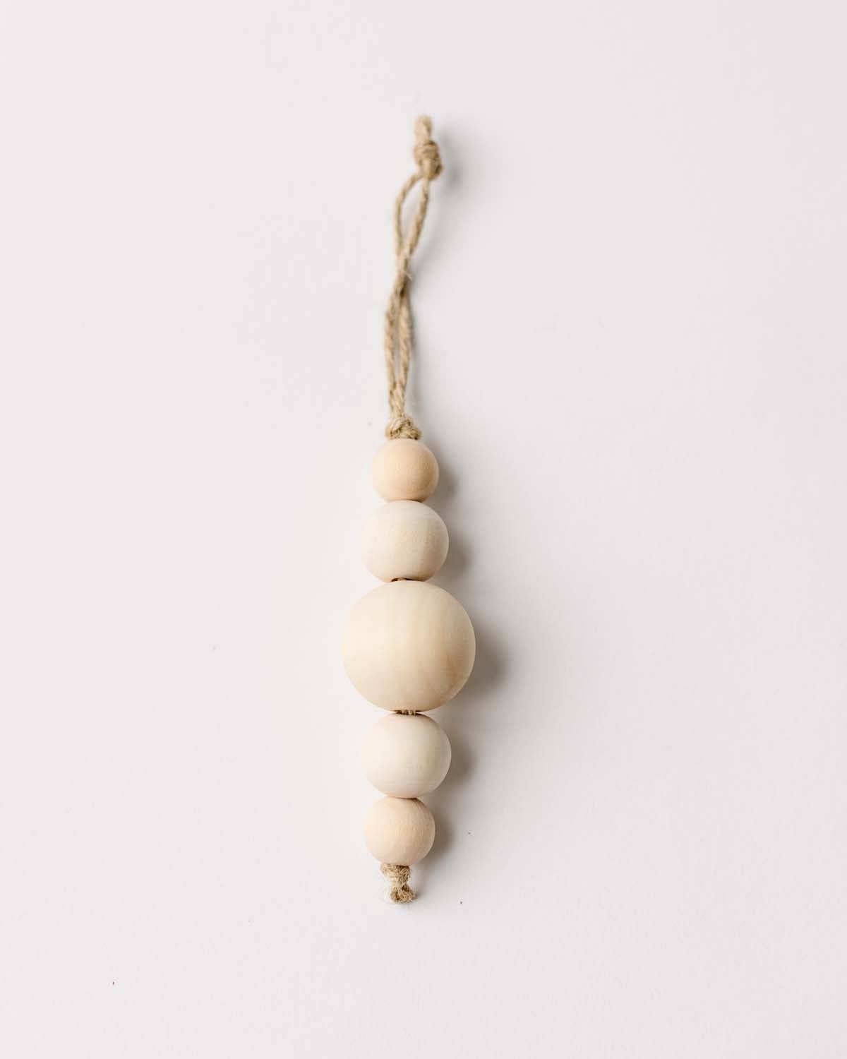 Decorative hanging ornament with wooden beads on a white background