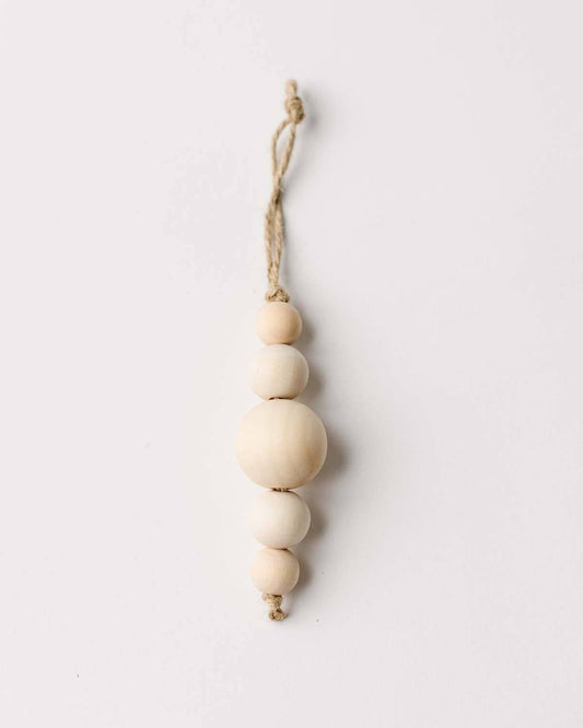 Decorative hanging ornament with wooden beads on a white background