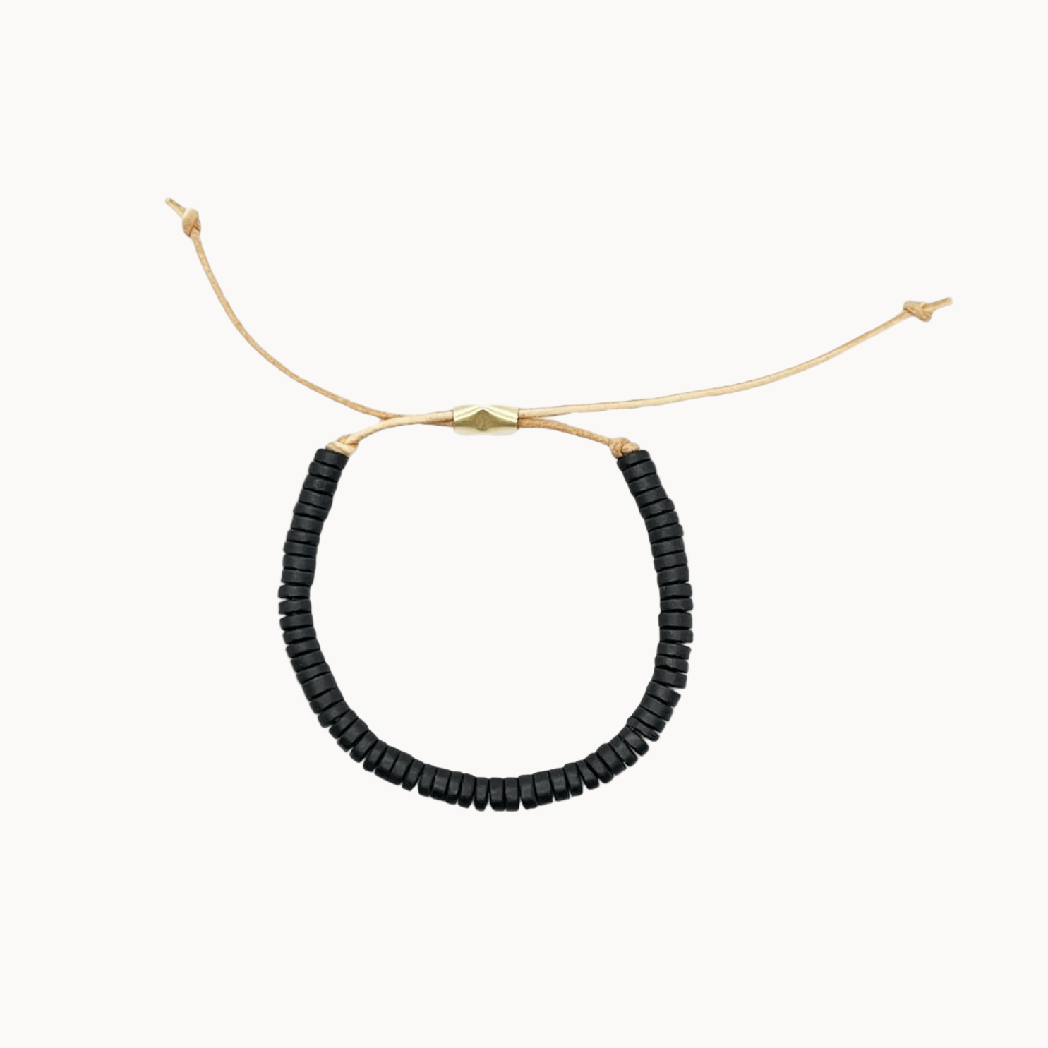 Black beaded necklace on a leather cord with gold clasp on a white background