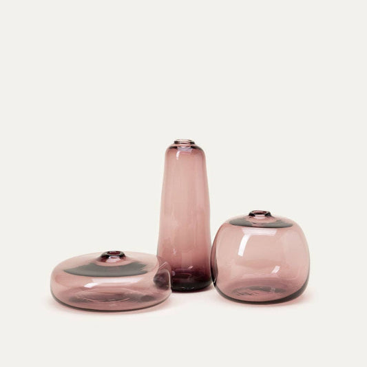 Three pink glass vases of different shapes on a white background