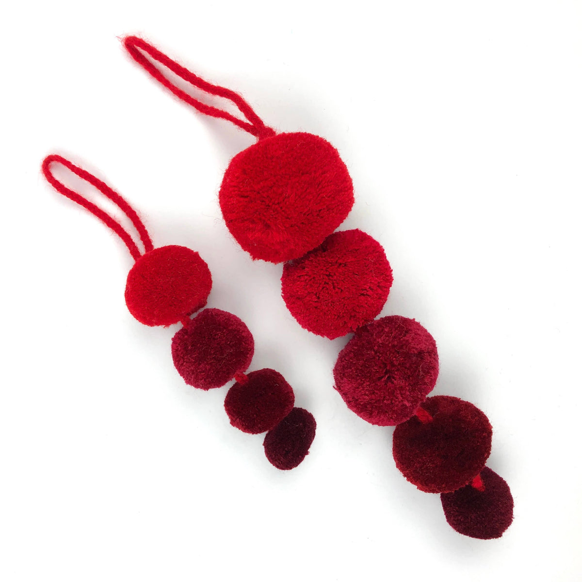 Red and burgundy pom-pom ornament on a white background