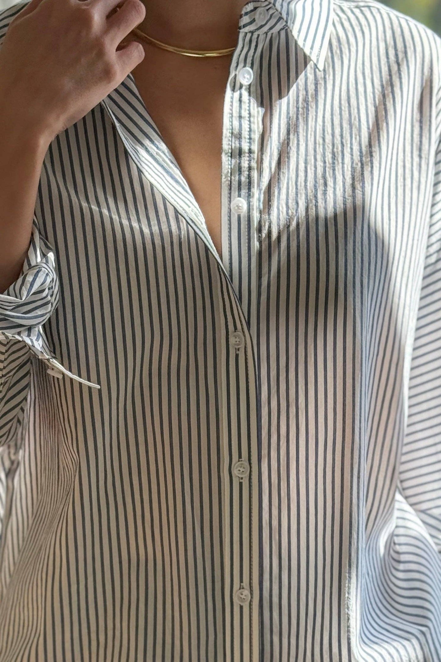 Close-up of a person wearing a striped shirt with a blurred background