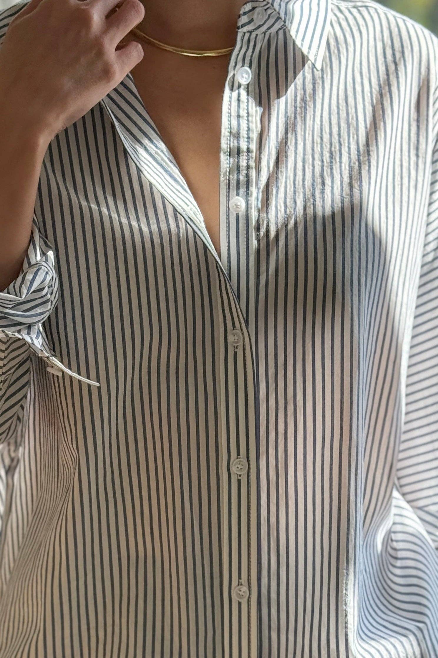 Close-up of a person wearing a striped shirt with a blurred background
