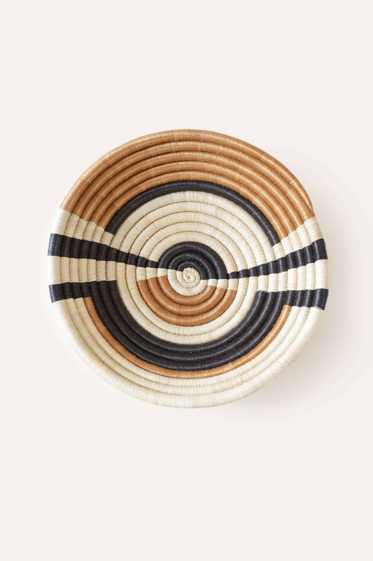 Woven basket with concentric circle pattern on a white background