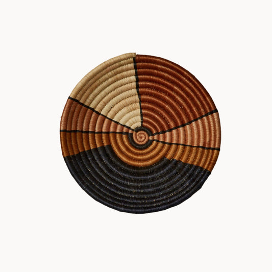 Woven basket with concentric circle pattern on a white background