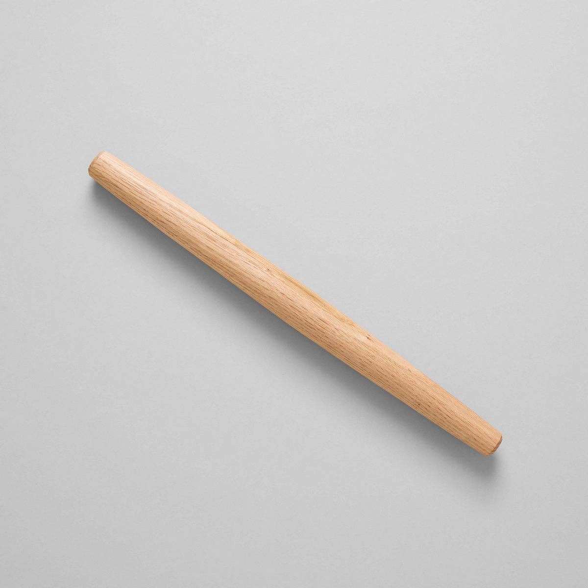 Wooden rolling pin on a light gray background