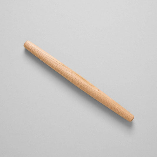 Wooden rolling pin on a light gray background