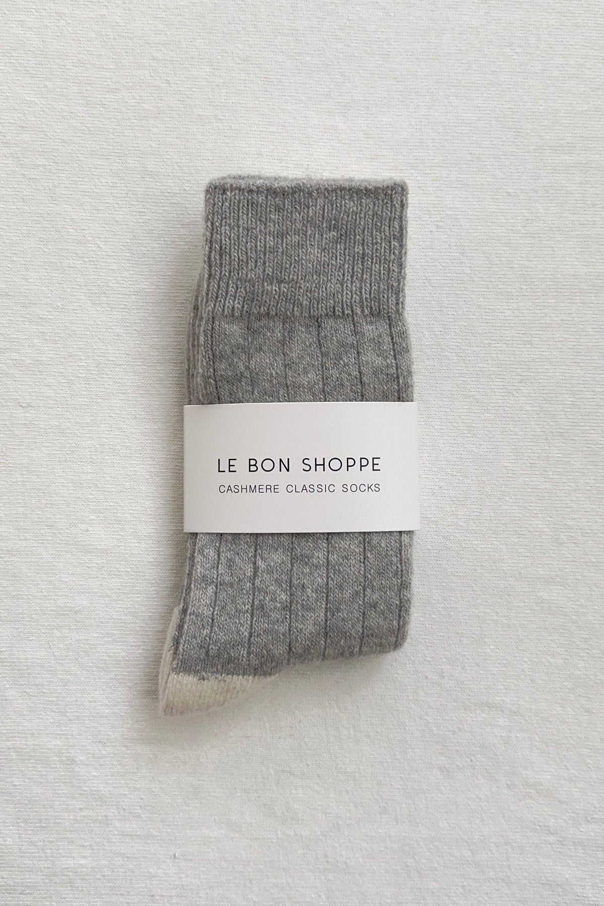 Gray cashmere socks with 'Le Bon Shoppe' label on a textured gray background