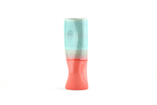 Tall cylindrical vase with gradient design from light blue to red on a white background