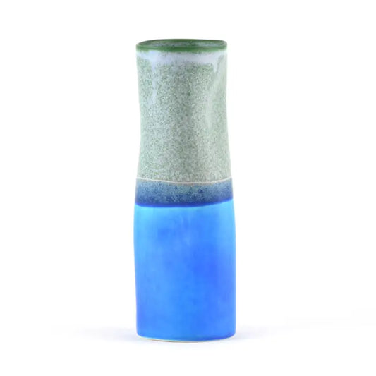Cylindrical ceramic vase with distorted shape and two-tone blue and sage green design on a white background