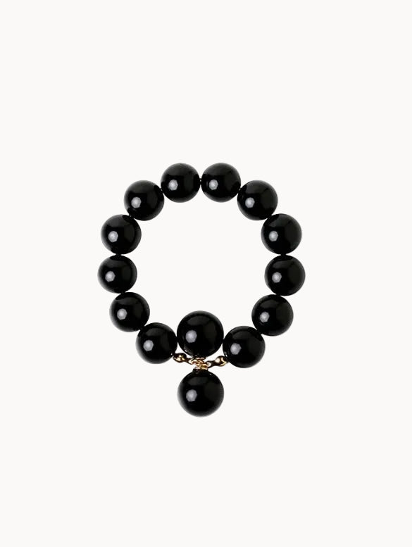 Black beaded bracelet with a gold charm on a white background