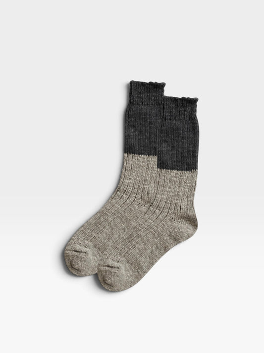 A pair of light and dark gray wool and cotton socks with a slub weave with a two-tone design 
