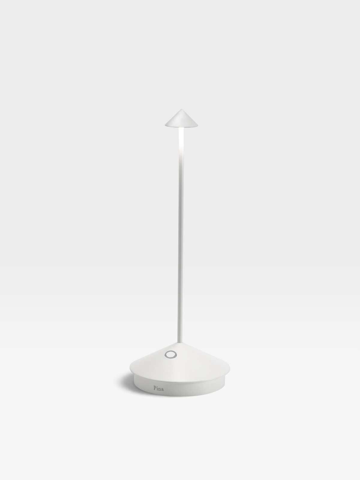 A white colored metal table lamp with a round base, long, slender neck and small, conical shade.
