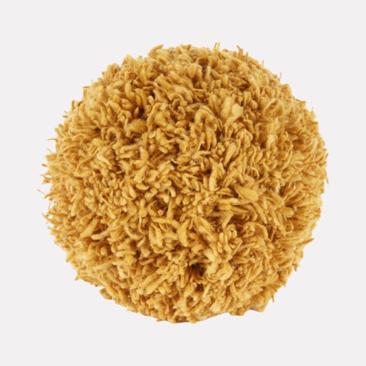 Gold-colored spherical tufted wool throw pillow sitting against a white background