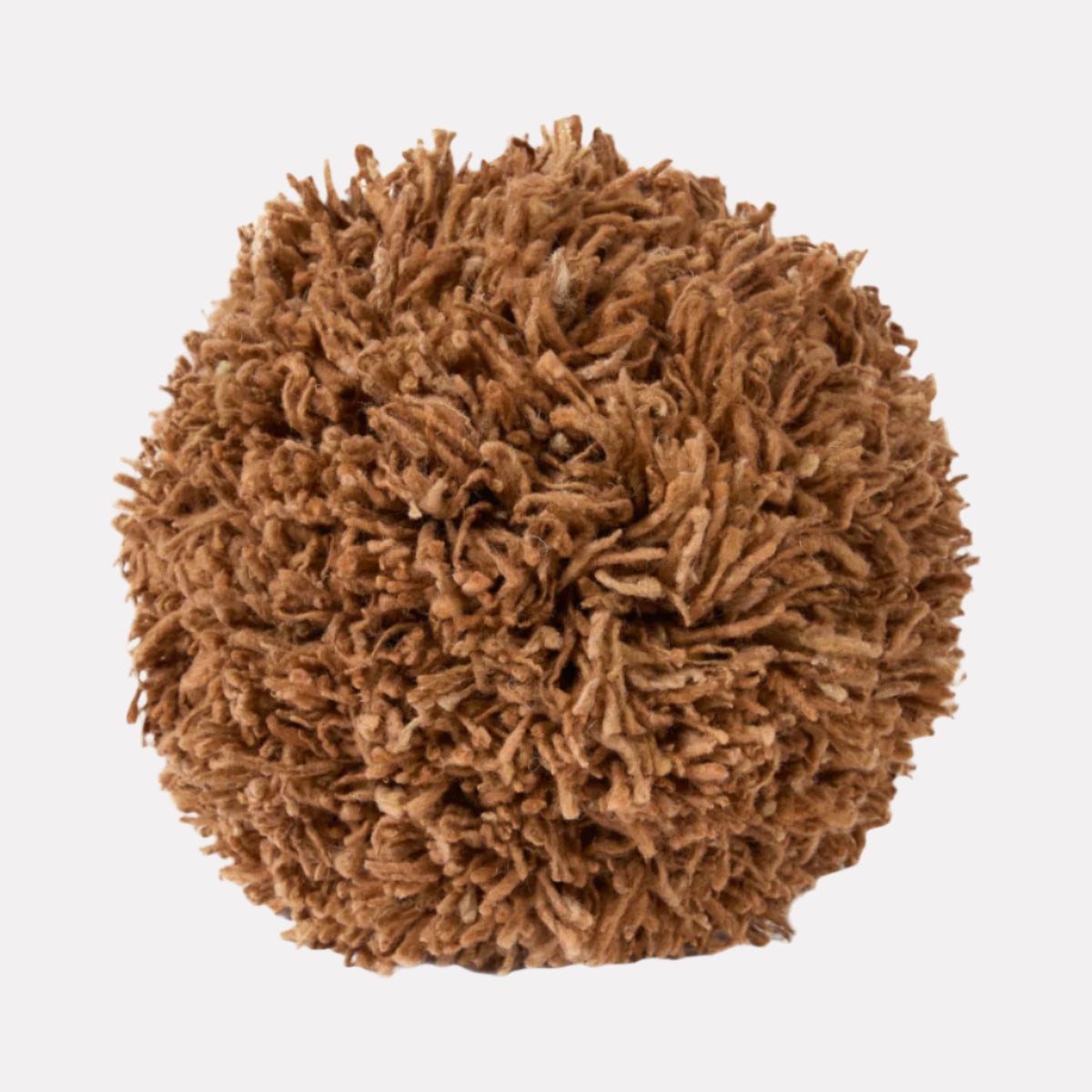 Light brown-colored spherical pillow made of tufted wool and sitting against a white backdrop