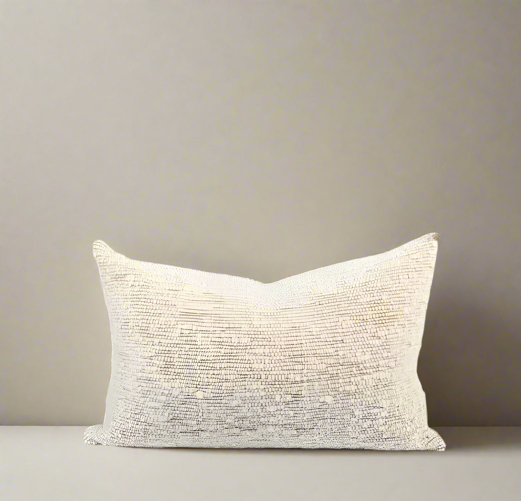 A beige, chunky wool lumbar pillow cover with a textured design.