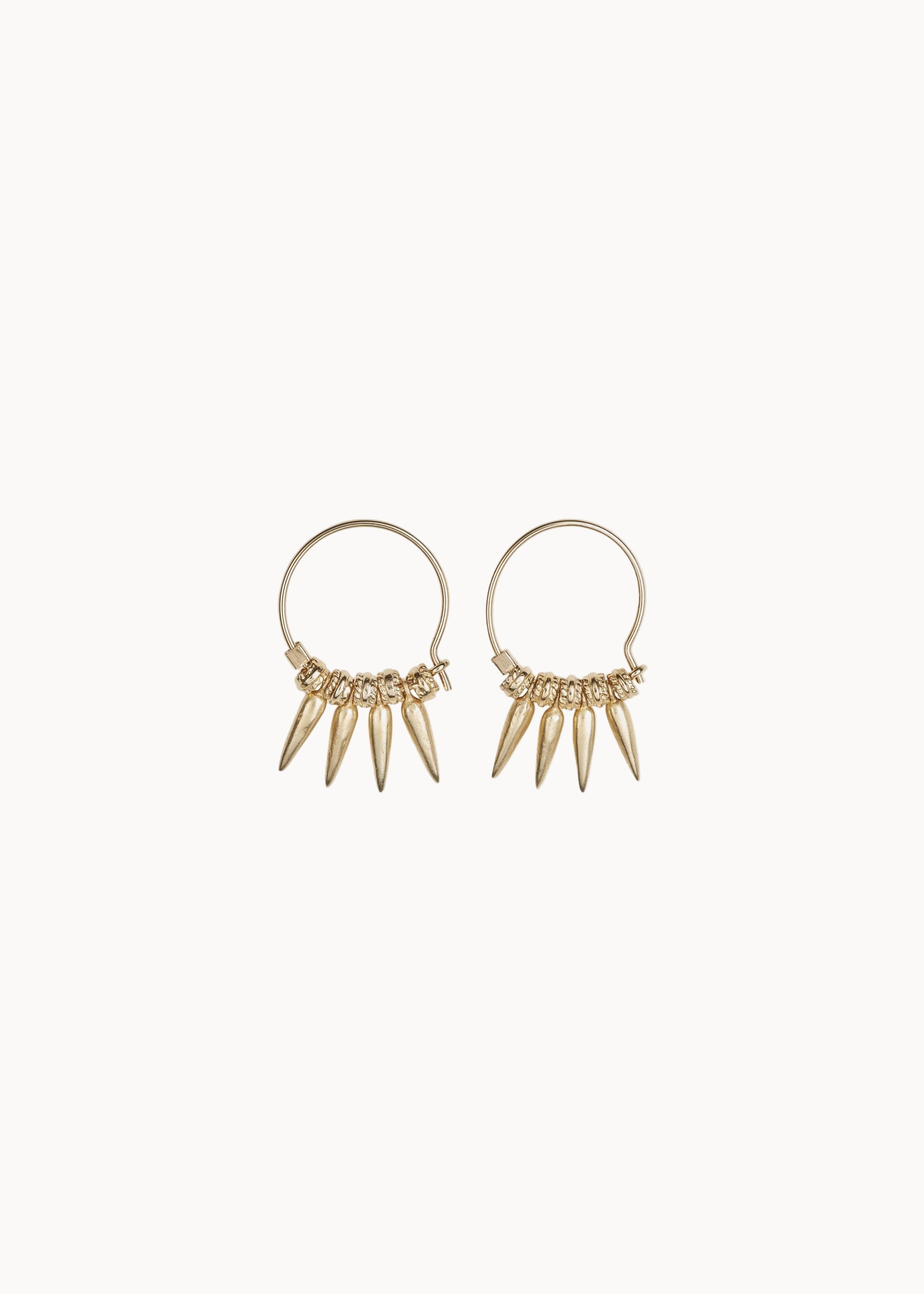 Gold hoop earrings with dangling spike details on a soft white background
