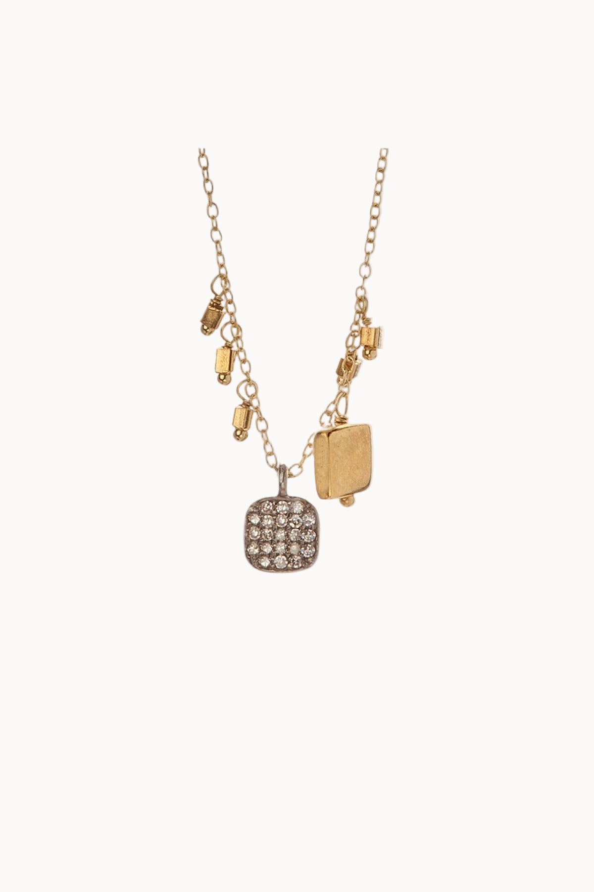 Gold chainlink necklace featuring assorted charms made of gold and diamonds hanging against a soft white background