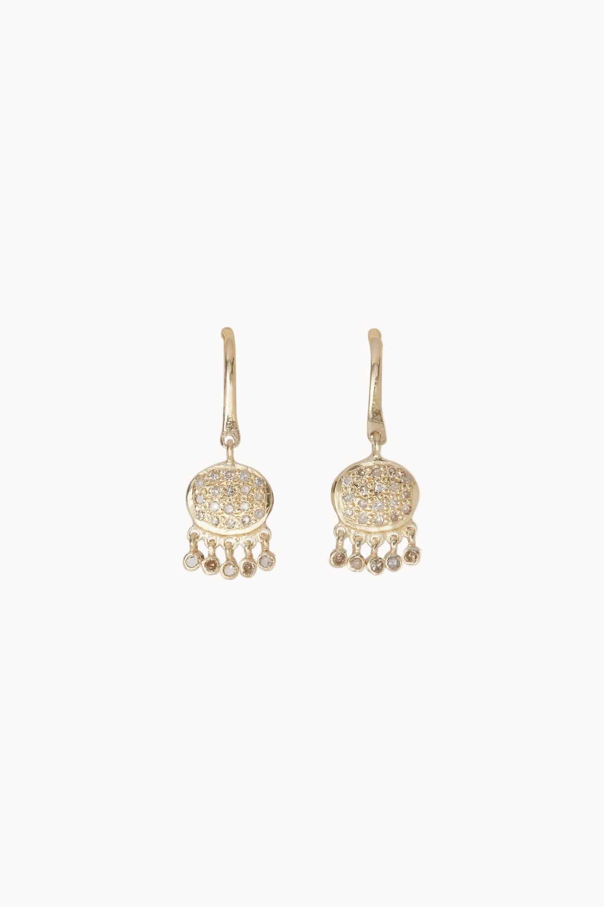 Pair of gold and pave diamond earrings with dangling elements on a soft white background
