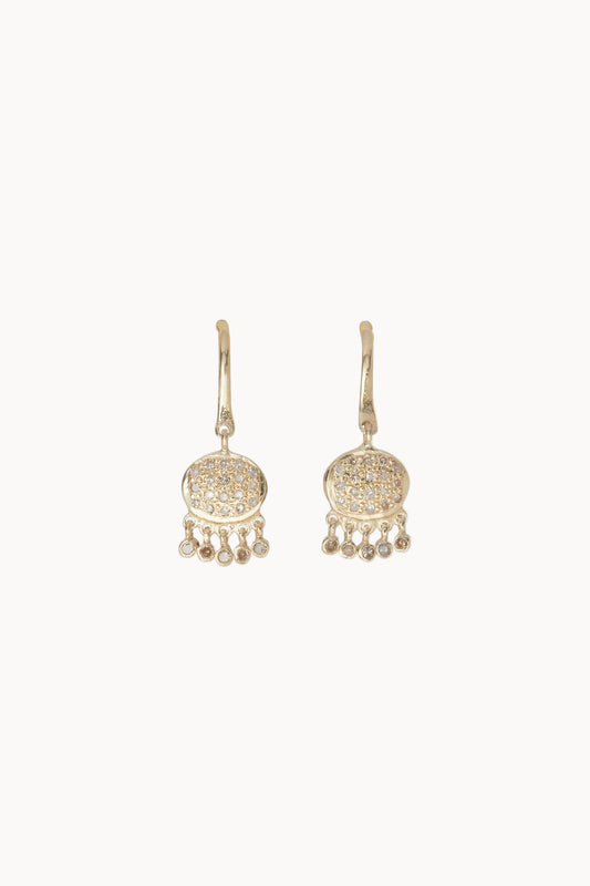 Pair of gold and pave diamond earrings with dangling elements on a soft white background