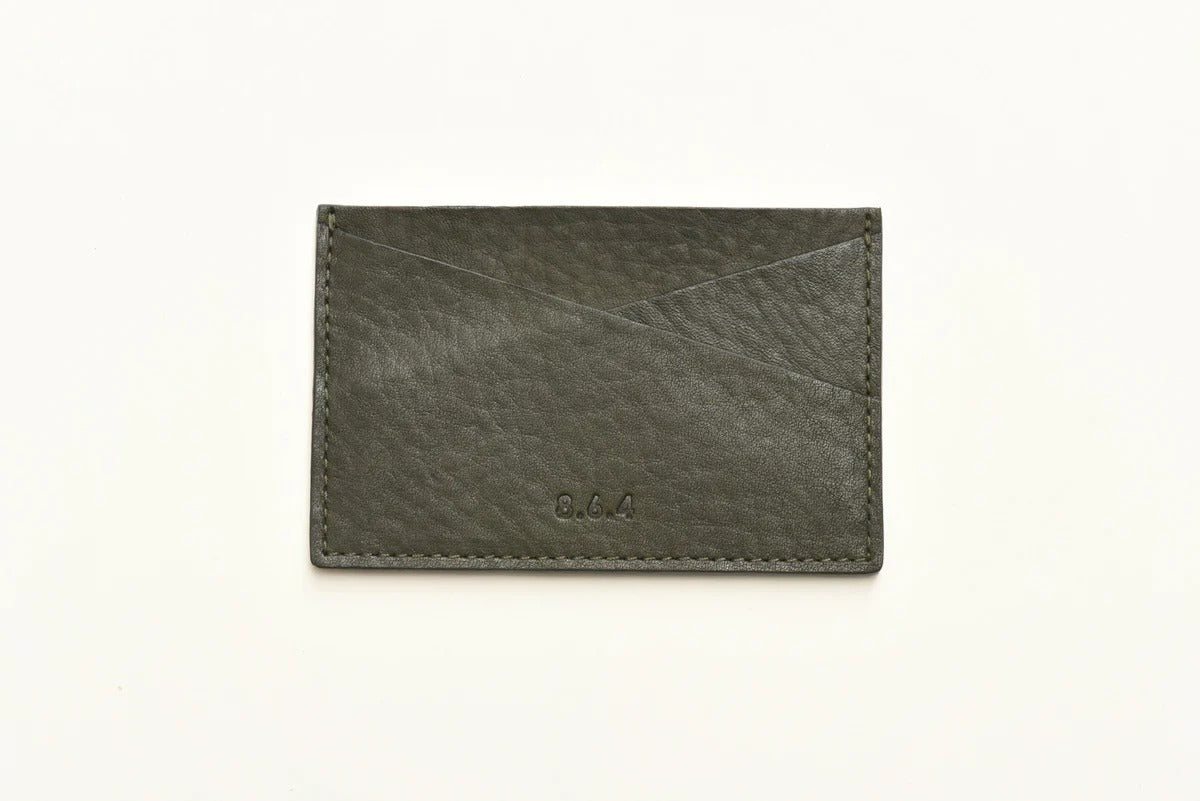 Dark green pebbled leather cardholder with on a white background