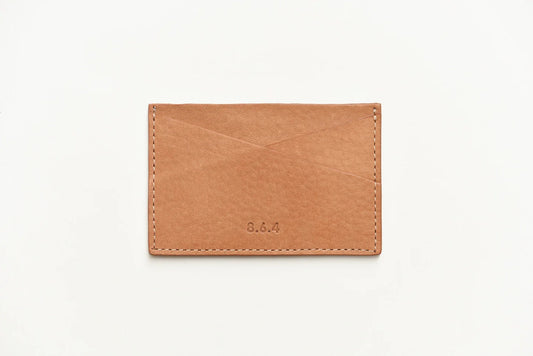 Tan-colored pebbled leather cardholder on a white background
