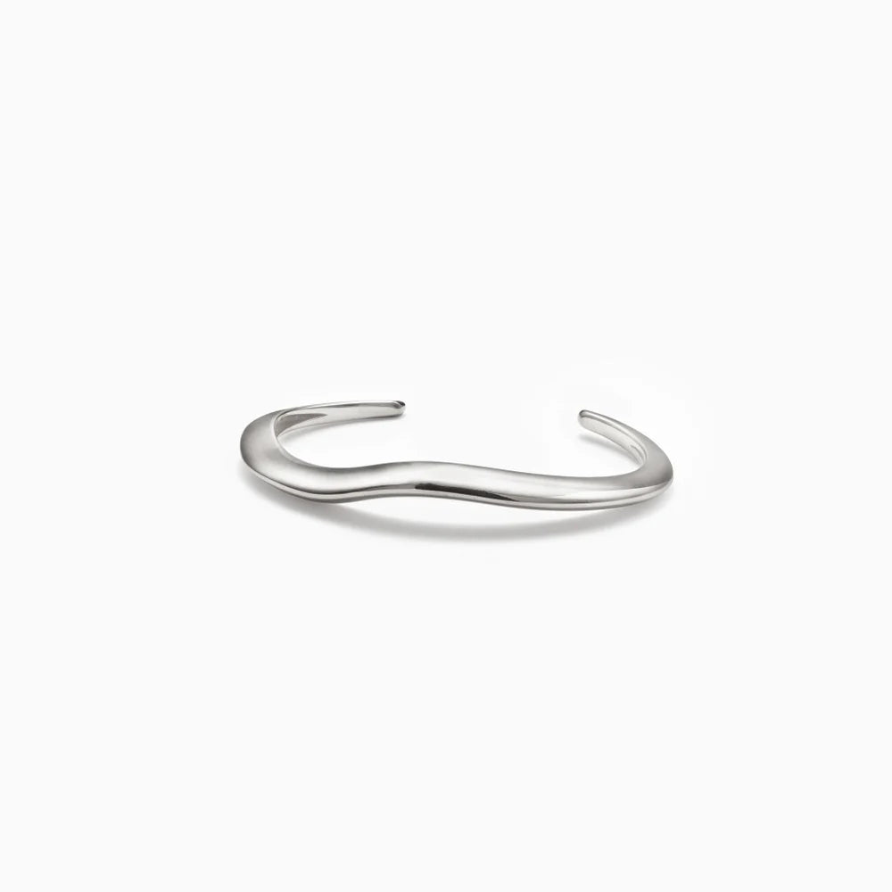 Curved silver cuff bracelet on a white background