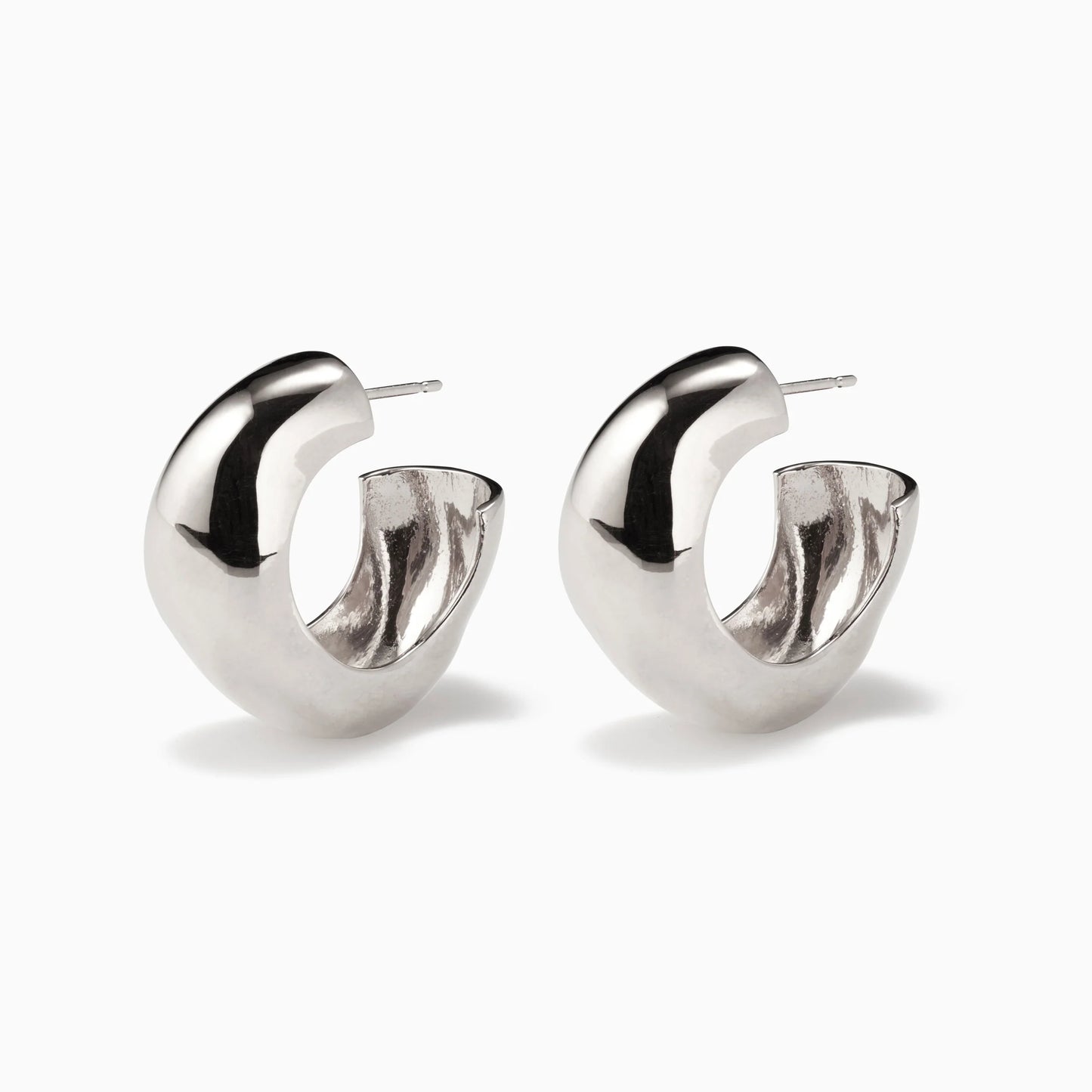 Pair of chunky, irregular-shaped silver hoop earrings on a white background