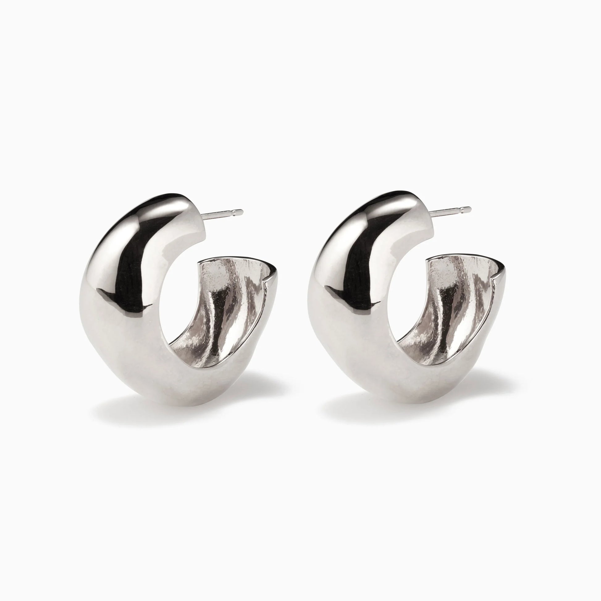 Pair of chunky, irregular-shaped silver hoop earrings on a white background