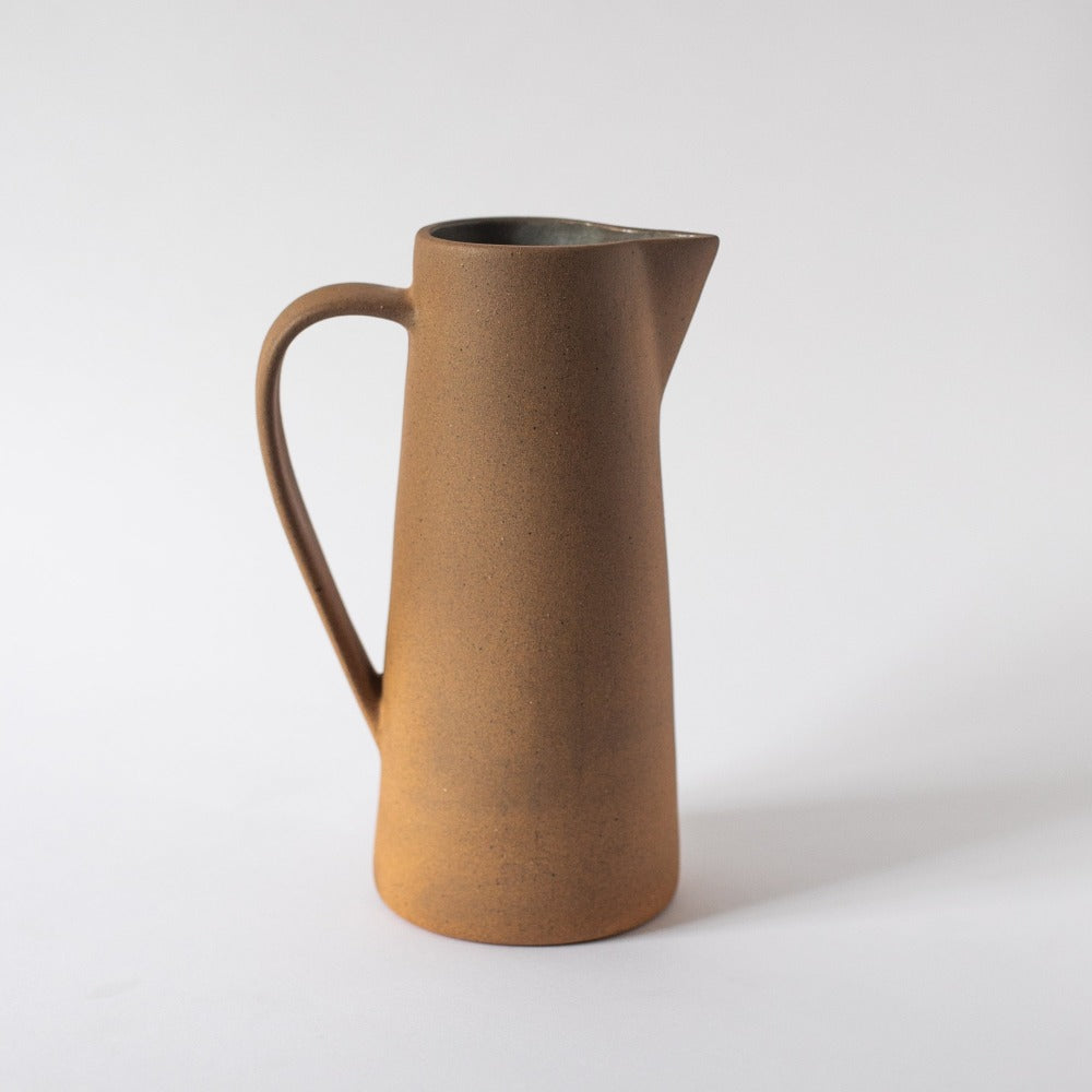 Brown ceramic pitcher on a white background