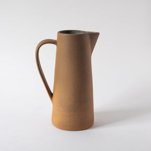 Brown ceramic pitcher on a white background