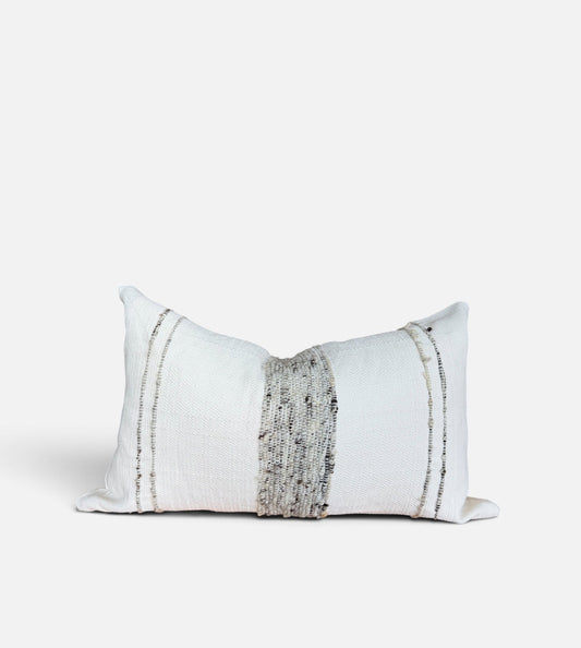 A rectangular white throw pillow with a central vertical textured gray stripe and two thin vertical metallic gold stripes on either side, shown on a light gray background.