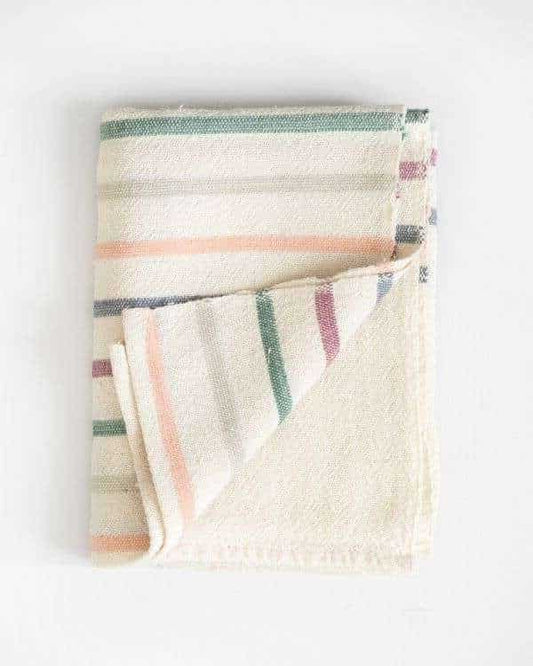 Folded cream-colored baby blanket with multicolored stripes on a white background