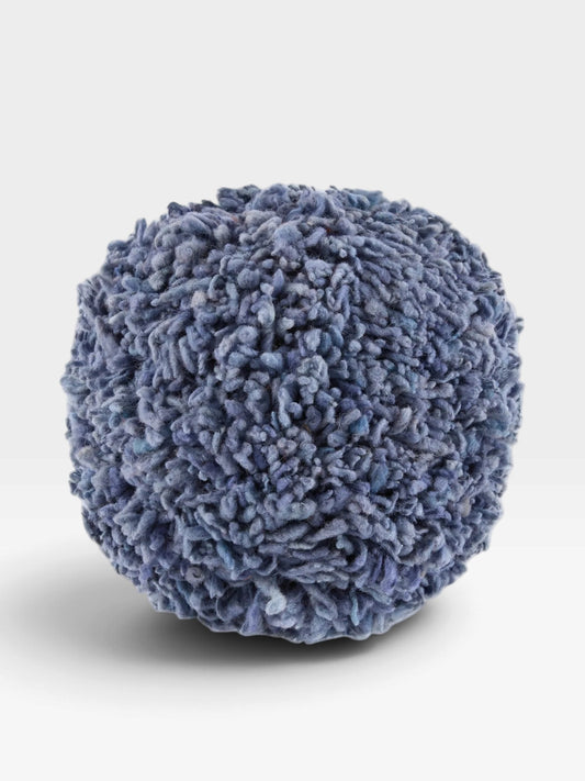 A round, textured pouf or ottoman with a shaggy, curly looped fabric in a dusty blue-gray color, shown on a clean white background.