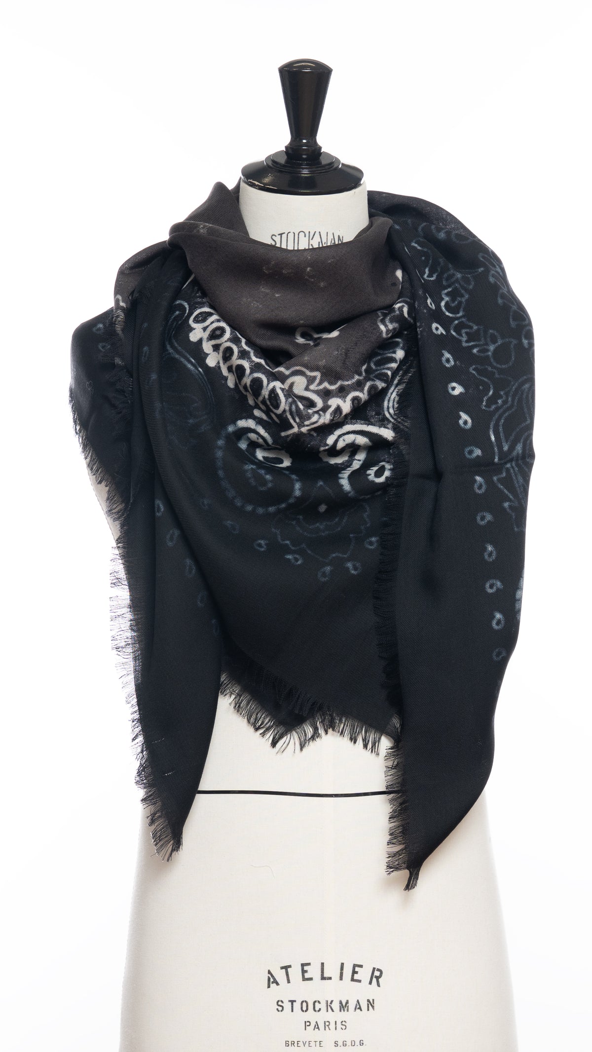 A black and dark brown-gray wool scarf with a white bandana motif draped around a mannequin bust and photographed against a white background.