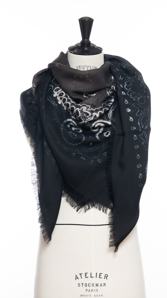A black and dark brown-gray wool scarf with a white bandana motif draped around a mannequin bust and photographed against a white background.