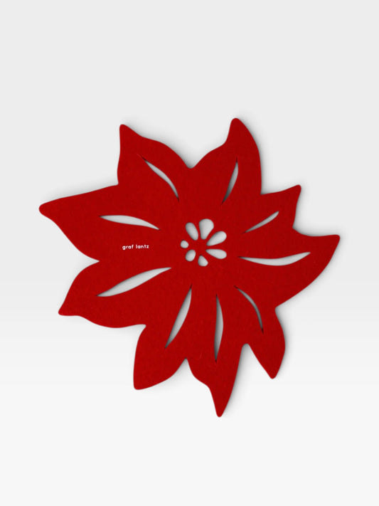 Red wool felt trivet in the shape of a Christmas poinsettia on a light gray background
